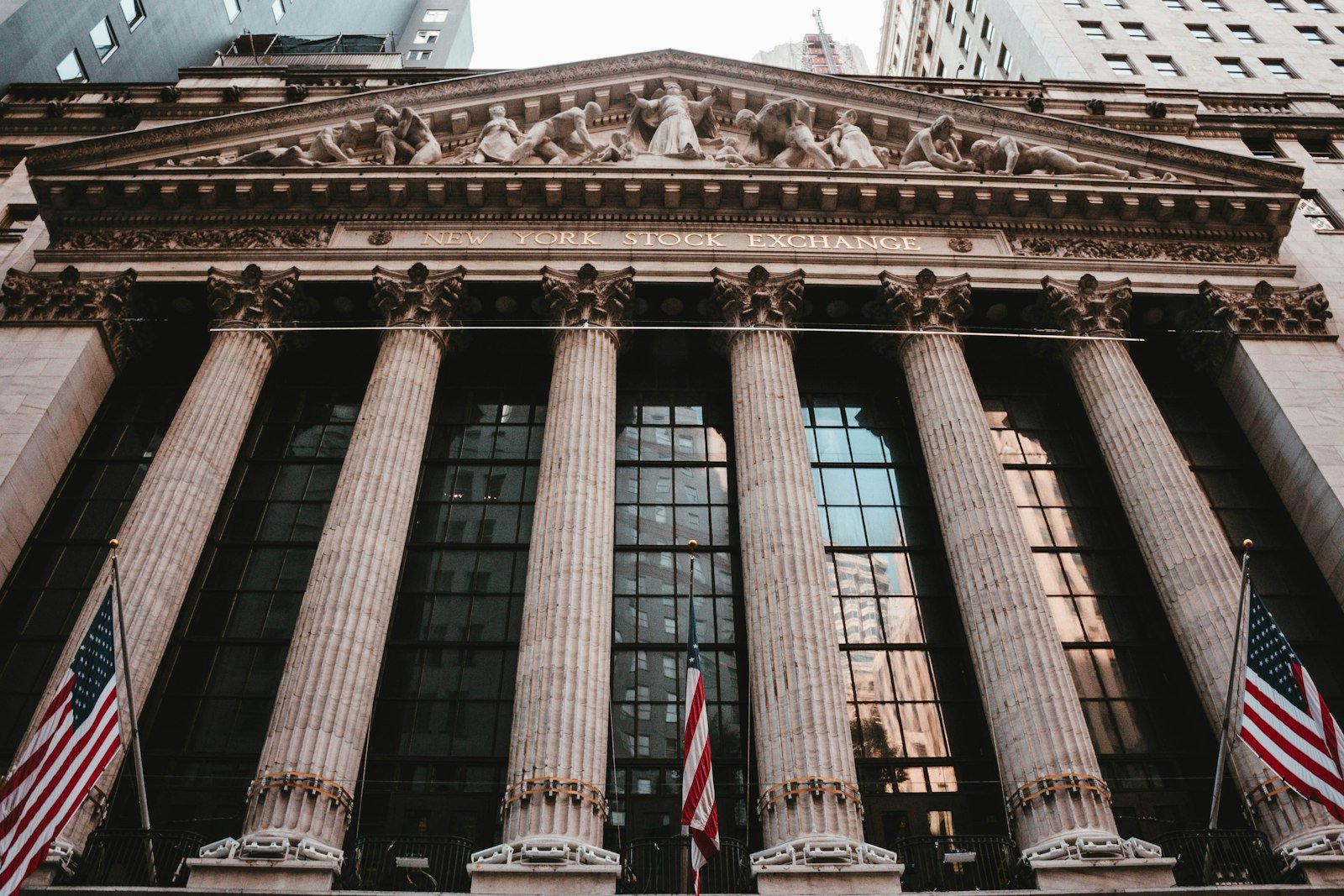 Il cartello di Wall Street a New York con le bandiere americane sullo sfondo